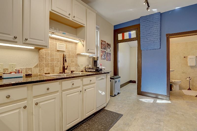Kitchen, bathroom and walk-through to back yard (brick is part of the historic chimney). Pantry shelves on right side in walk-through.