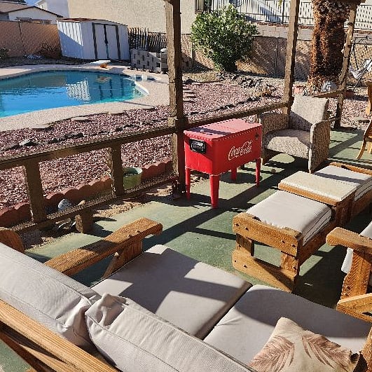 Comfy back patio with custom patio furniture, large cooler, mini fridge if needed and full sized propane BBQ grill.