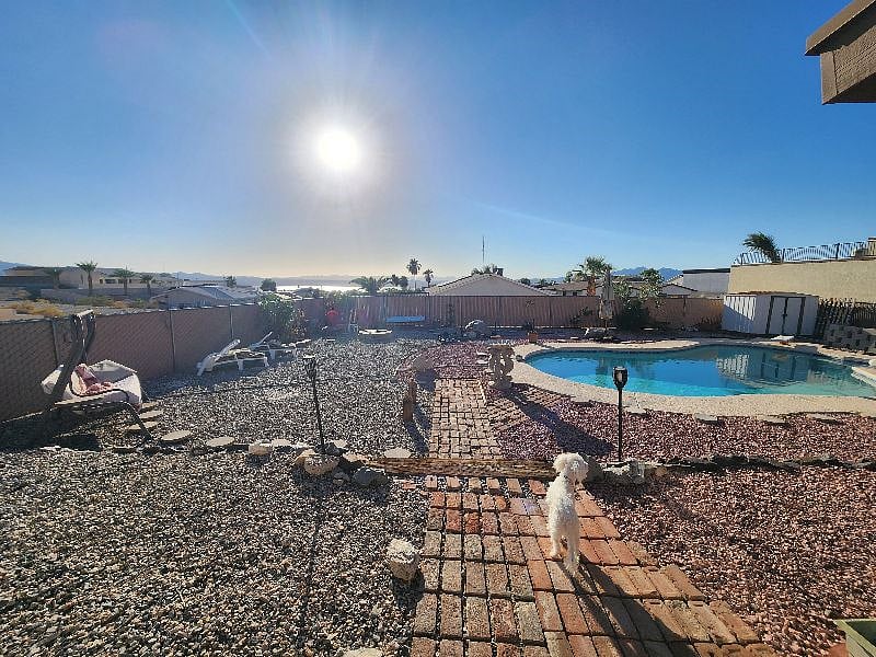 Bi-level back yard with 3 steps to lower level with pool.