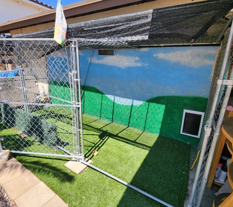 Attached fully enclosed pet kennel with gate.