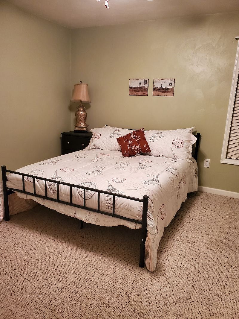 Master bedroom with queen bed a night stand and dresser.