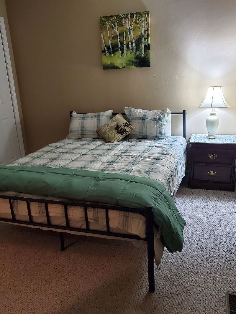 Bedroom 2 with a queen bed and two pillows.