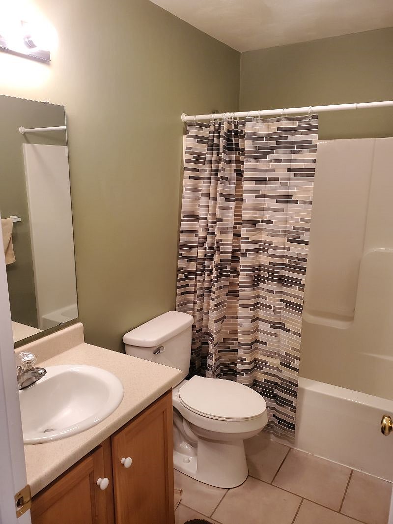 The hall bathroom with a tub/shower combo and large vanity.