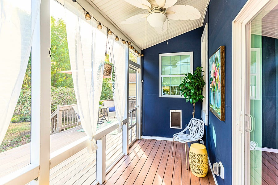 The spacious deck is a favorite spot for morning coffee with this screened porch with a ceiling fan. It opens to the deck overlooking the fenced backyard where dogs love to play!