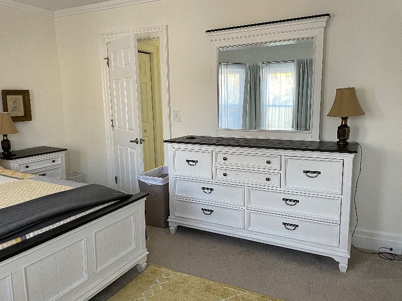 master bedroom with large dresser and nightstand with charging station and charging cables