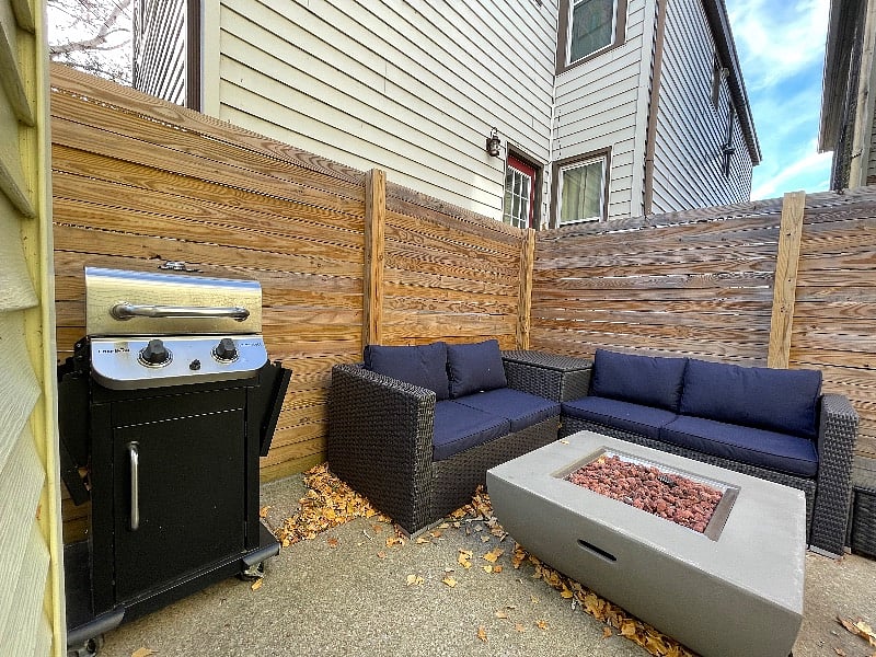 enclosed patio with seating, natural gas fire pit and propane grill