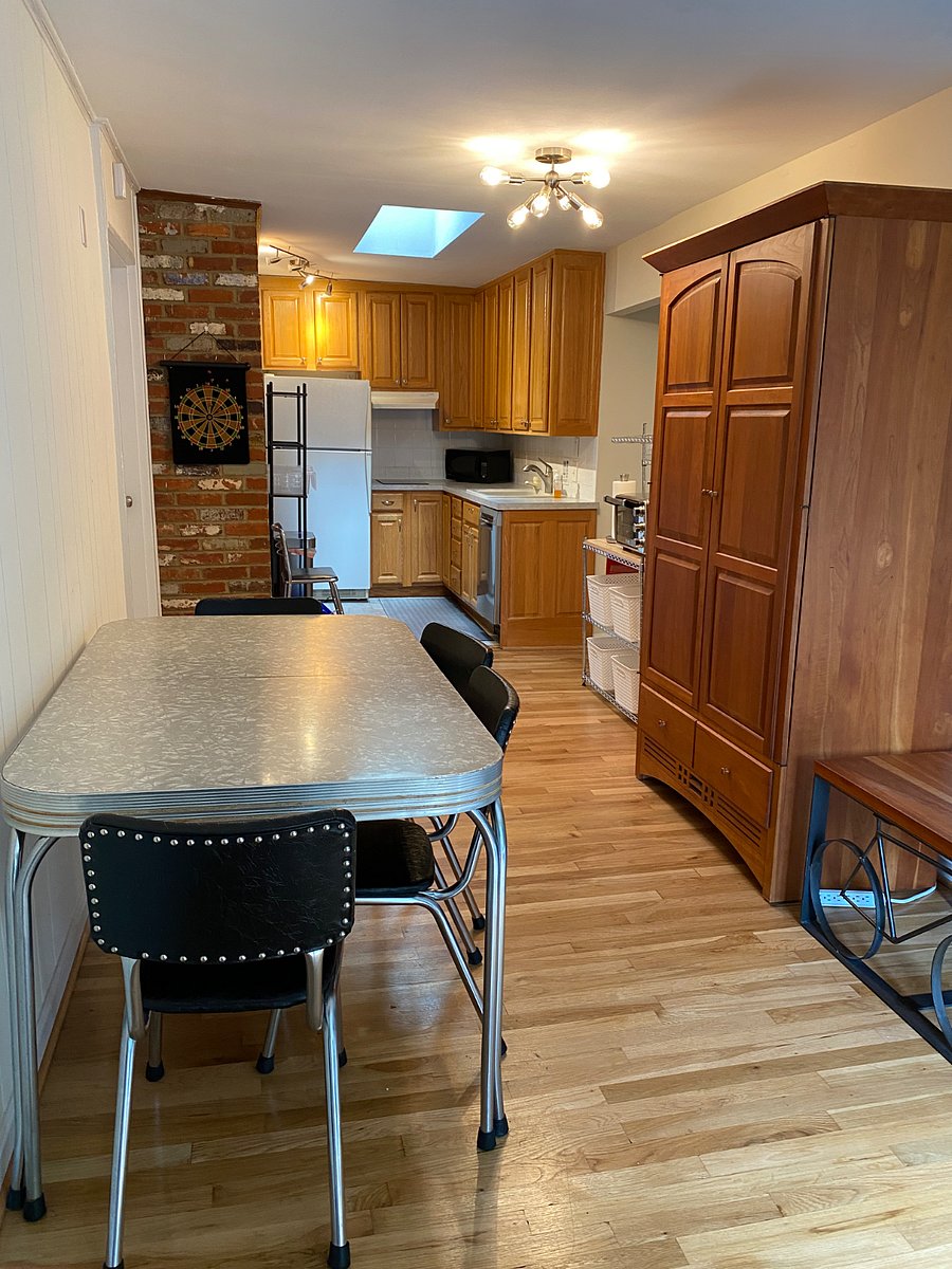 Kitchen and dining area features a vintage dinette set and solid-wood cherry armoire and bakers rack for plenty of storage