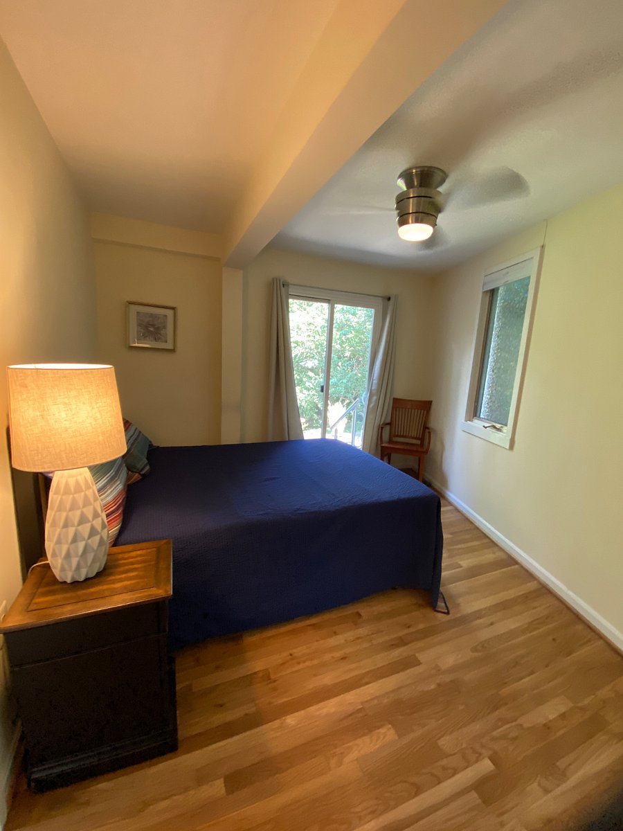 Bedroom features a queen-sized temper-pedic bed, ceiling fan/light, sliding doors to back patio