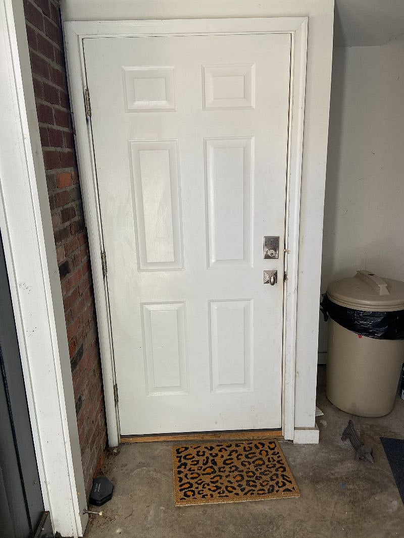 entrance door with keypad lock, located inside single garage. 