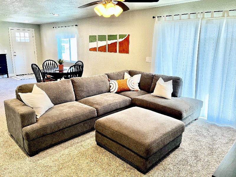 Large Thomasville sectional and ottoman in living room.