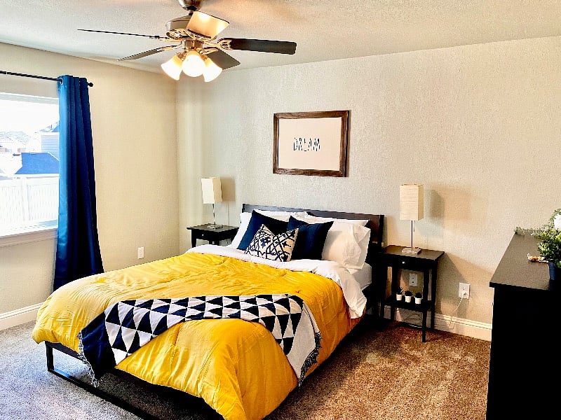 Large main bedroom with natural light and blackout curtains.