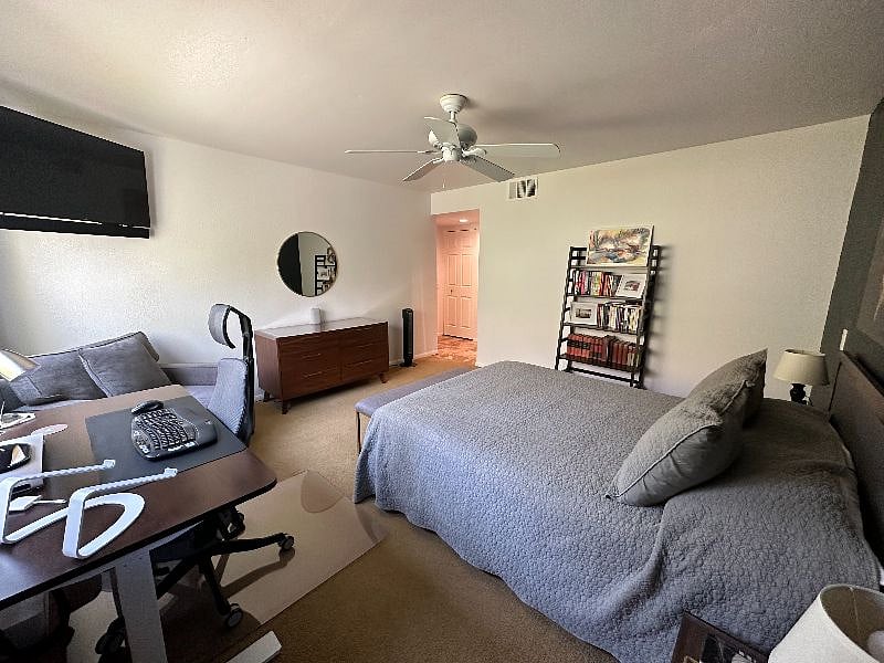 The corner primary suite offers an ensuite bath, an armchair, wall-mounted 50-inch HD TV with sound bar + Apple TV and workspace with standing desk with plenty of storage in a large dresser, two nightstands, and an in-room closet.