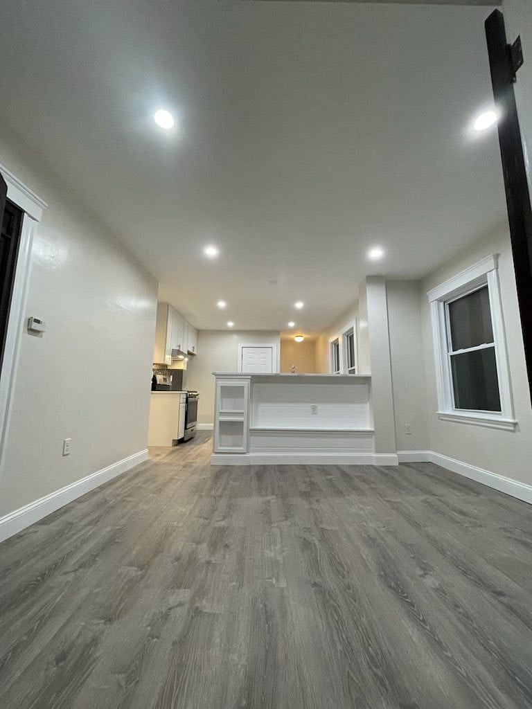 Dining room view (shown empty here). Room has four seat dining room set and two large stools for breakfast bar.