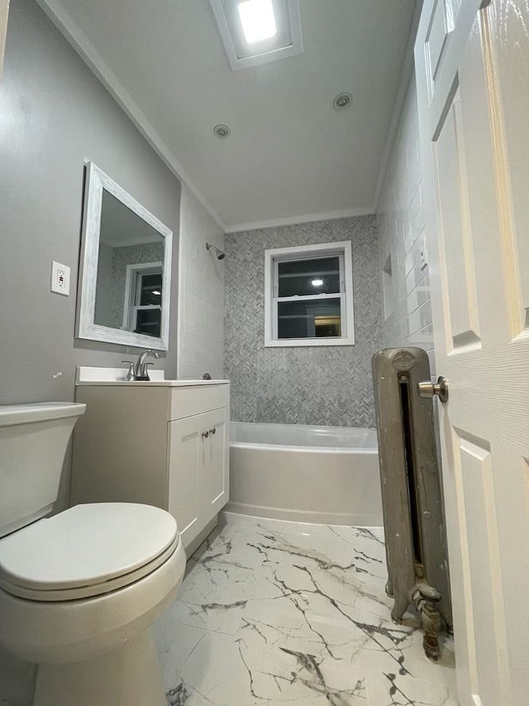 Bathroom w/ storage unit above WC. Shower and Bath and radiator