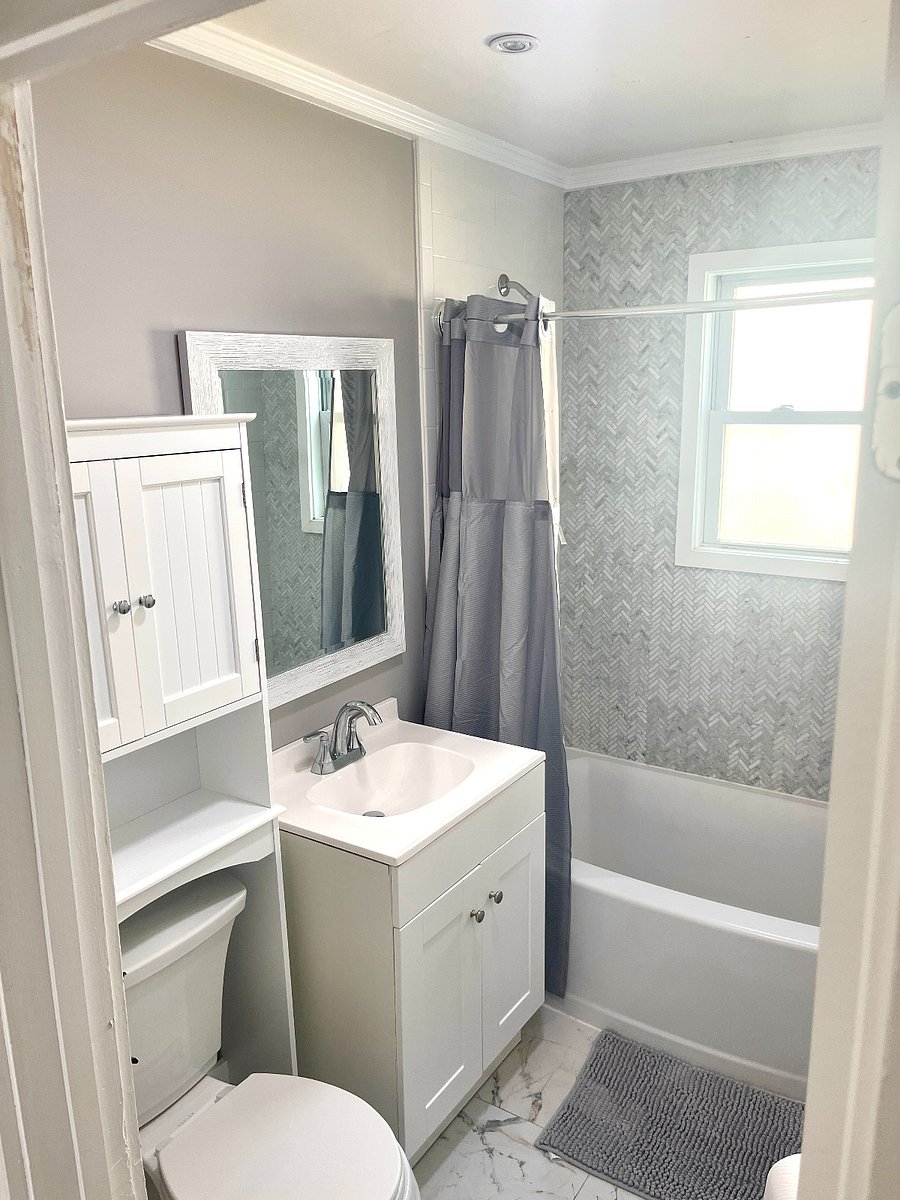 Bathroom w/ storage unit above WC. Shower and Bath and radiator 