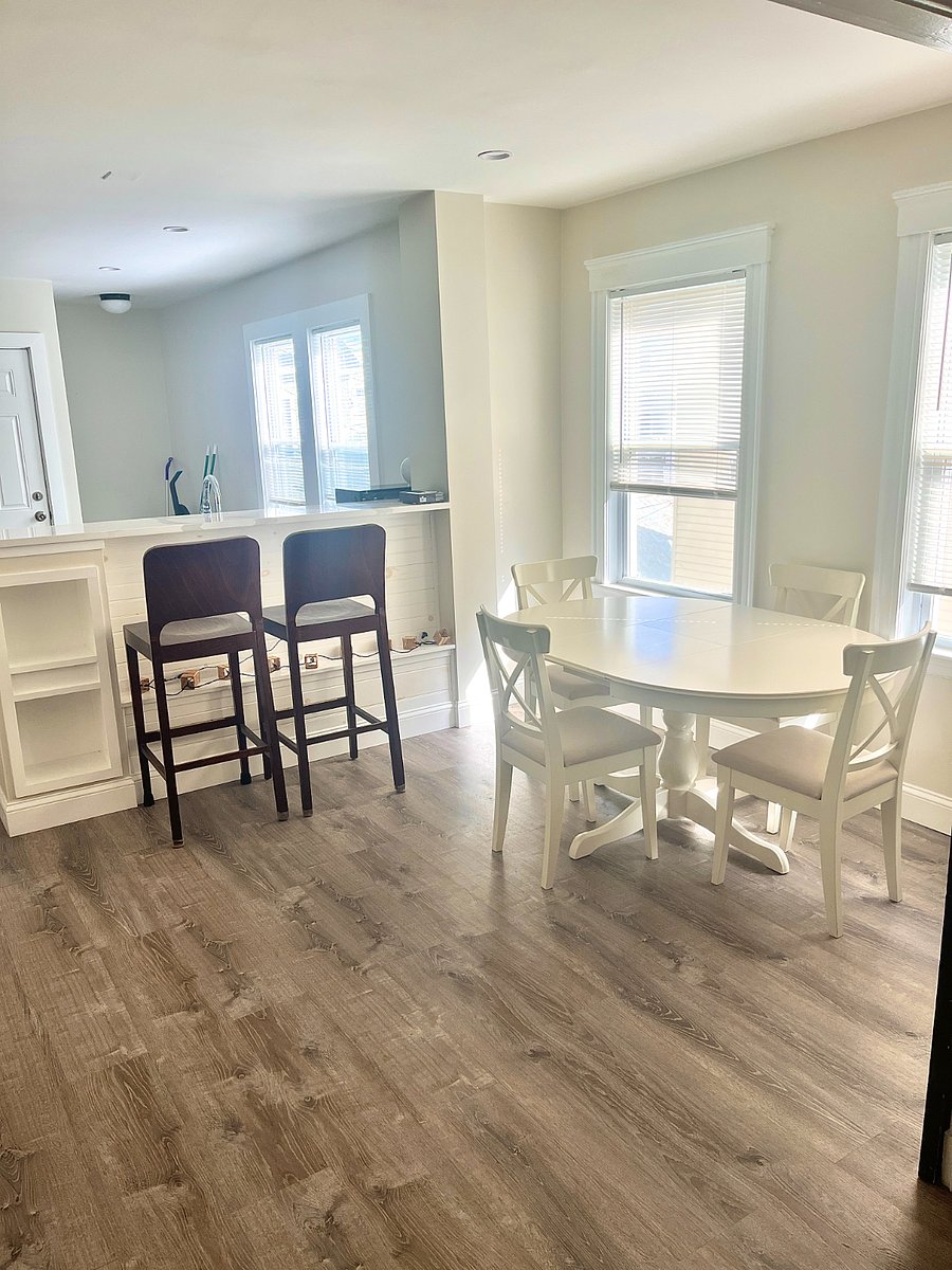 Dining room w/ dining room set. Two high backed stools at Breakfast bar. Well lit room and great layout with china cabinets and french doors into living rooms.