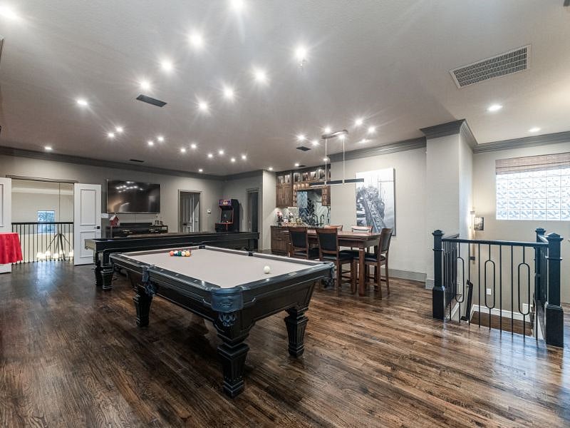The Game Room - designed after a modern twist on a 1920's speakeasy, this is your primary living area with pool table, shuffleboard, game table, bar/kitchen, cocktail table, couch and OLED TV.