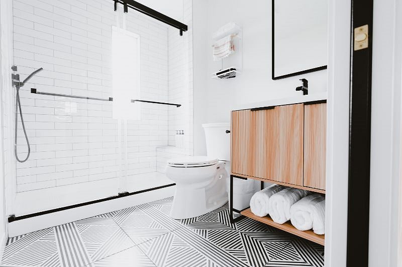 Clean, new and modern bathroom. Larger walk-in shower with built-in bench. The mirror has a medicine cabinet for extra storage.