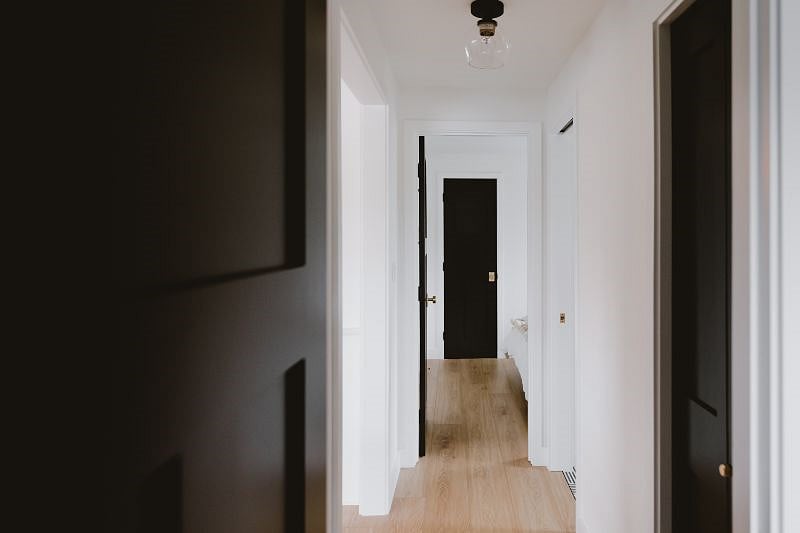 Modern hallway with the two bedrooms on either end and the bathroom and hall closet in the middle.
