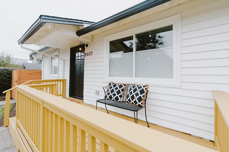 Front of the home with a yellow front porch and fantastic views of Mt. Si on a clear day.