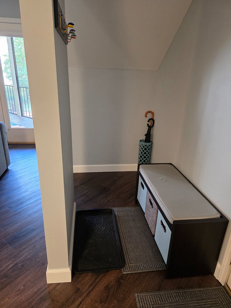 Entry nook has a small seating area with cube storage, mats for your shoes, key organizer, and umbrellas.