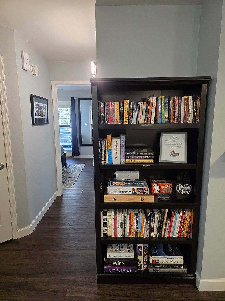Hallway and bookcase. The top two shelves are our book exchange. The third shelf has a variety of games, puzzles, cards, etc.