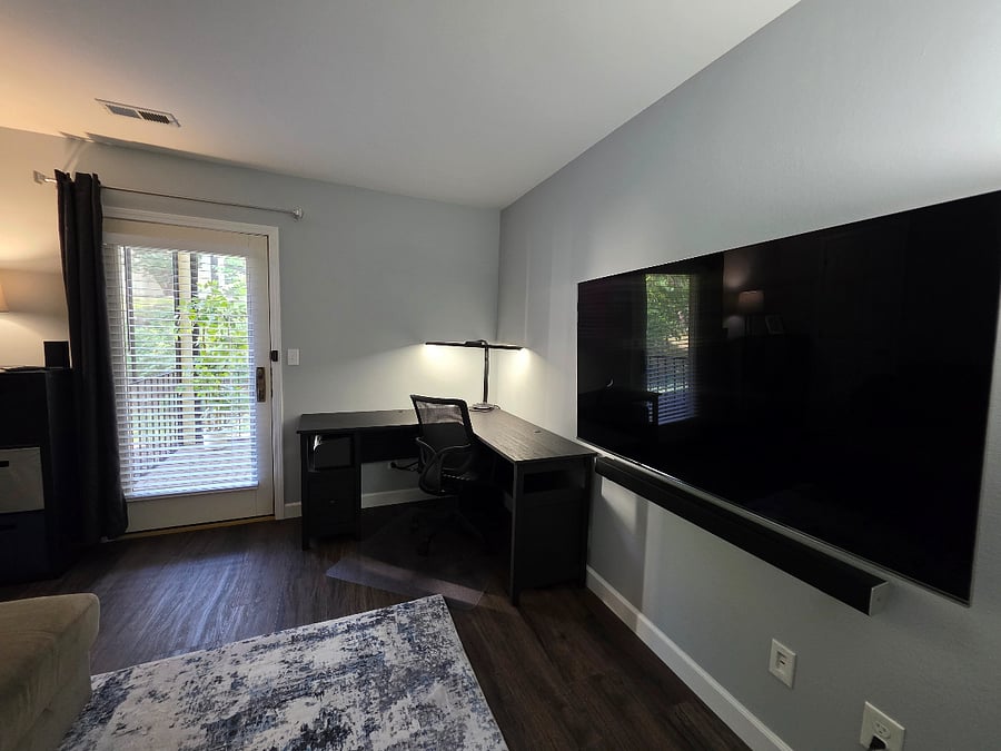 Office (second bedroom) has a large LoveSac couch that doubles as a queen sized bed, cube storage, L-shaped desk, and large TV.