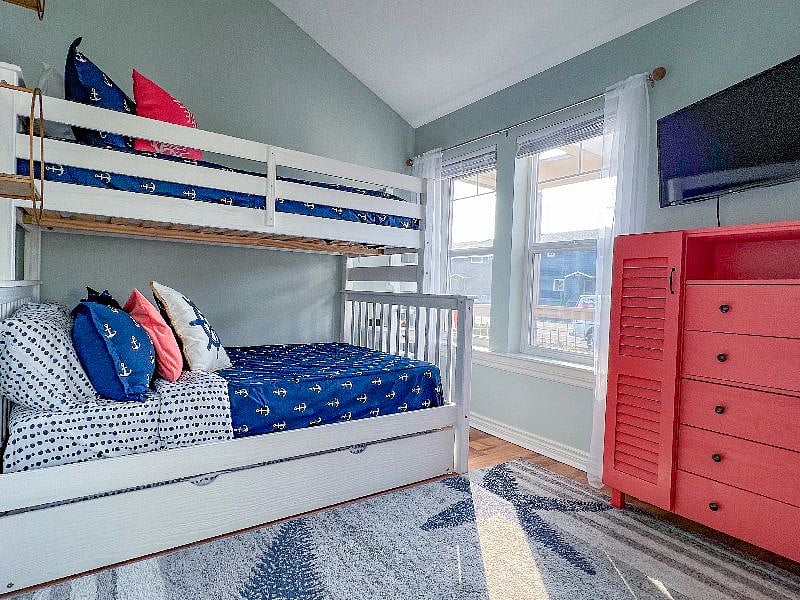 Front bedroom has a twin over double bunk bed, with a twin trundle. The room also has a smart tv and sliding double doors to the main living space.