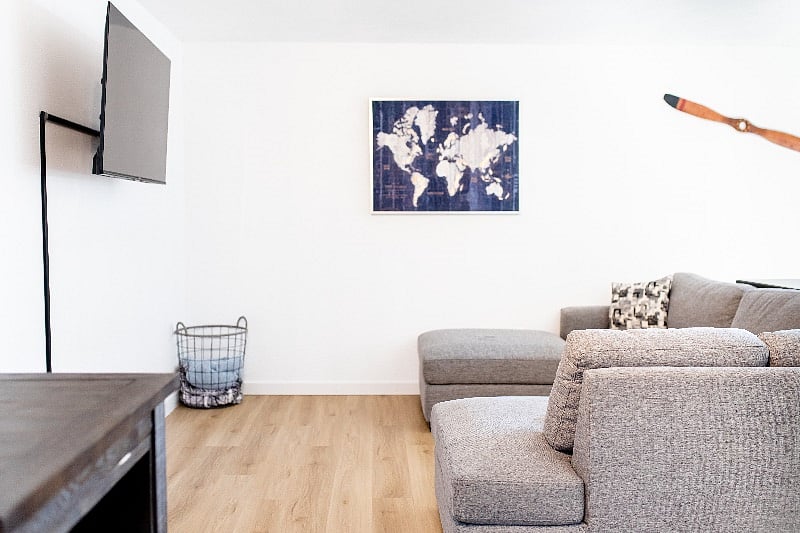 Spacious living room, with 2 tables to dine at, comfortable sofa, and throw blankets.