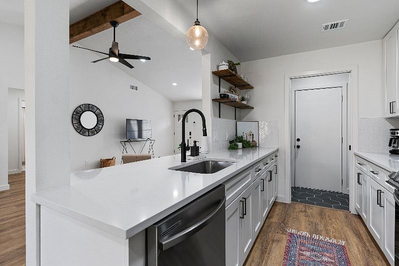 The kitchen is equipped with a sink and stainless steel dishwasher, along with thoughtfully provided supplies for added convenience.