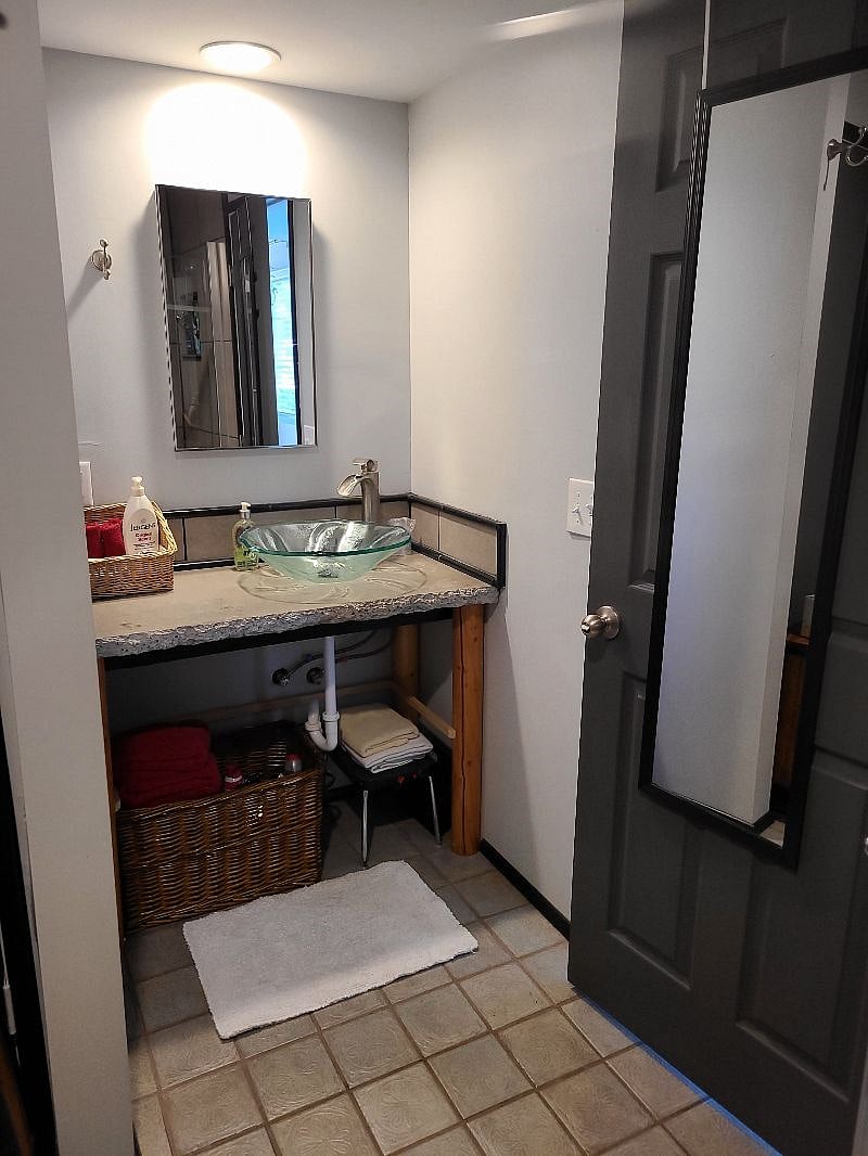 Medicine cabinet, sink, extra towels, hair dryer and other bathroom items