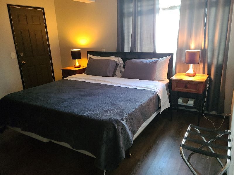 Bedroom with king bed, black-out curtains & side tabes