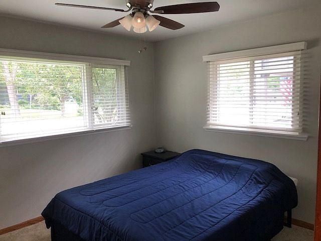This is the master bedroom that is carpeted and has a mirrored closet door. -