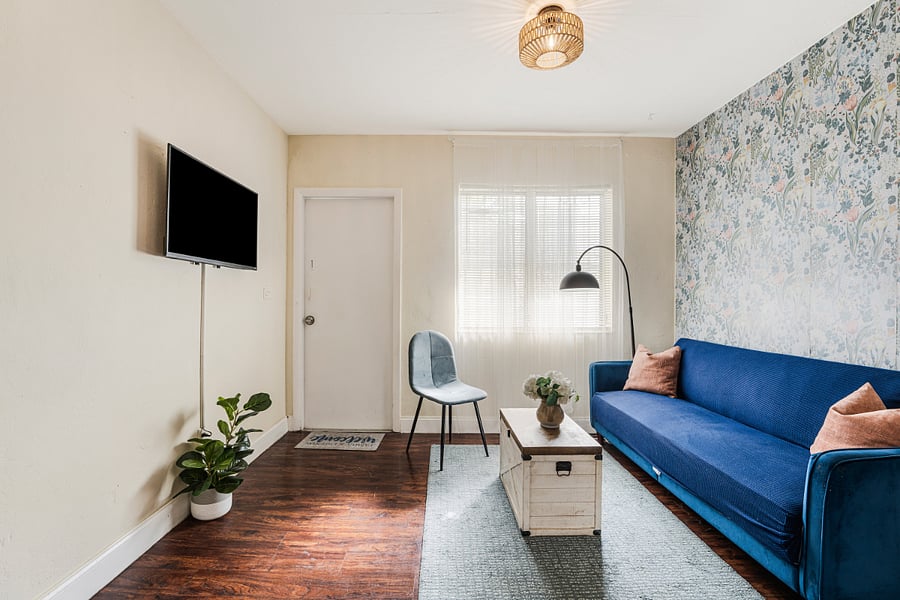 Bright and cozy living room featuring a modern sofa, warm natural light, and a welcoming atmosphere, perfect for relaxing or entertaining