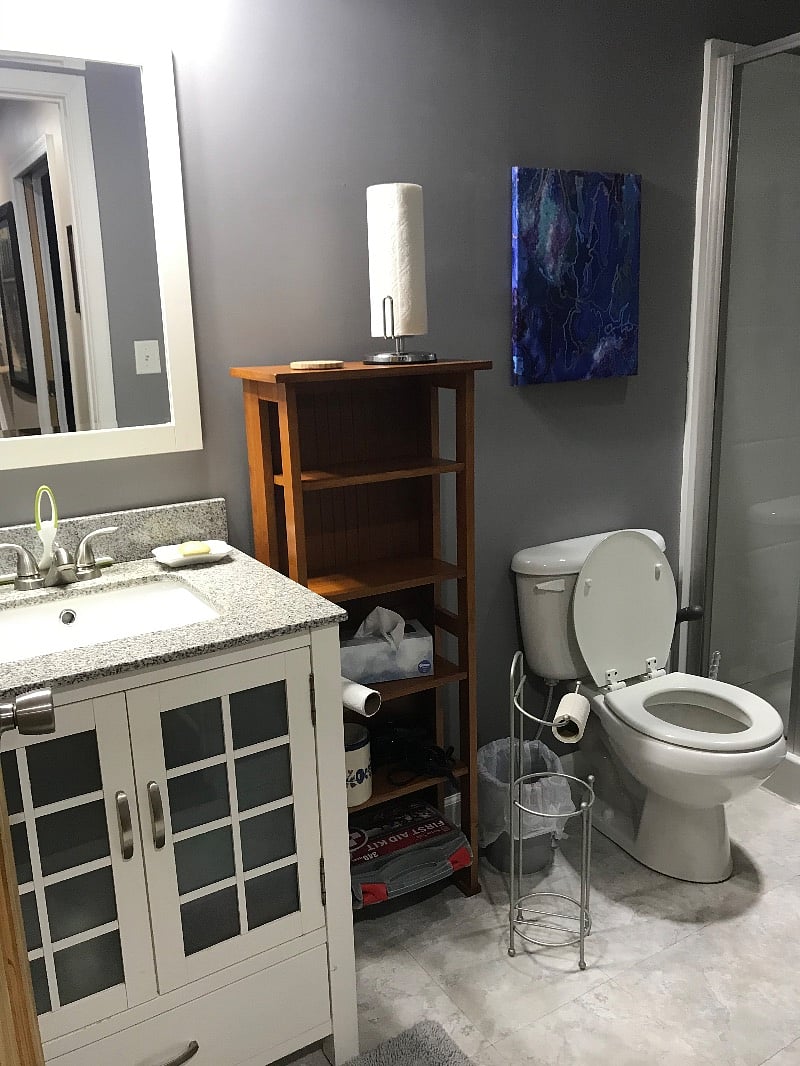 Full bathroom with stall shower and storage