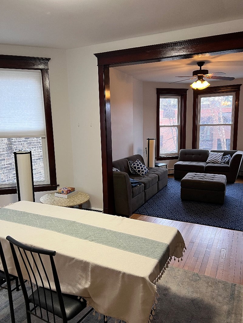 View into living room: LG smart television, bay windows, and tons of natural sunlight. 