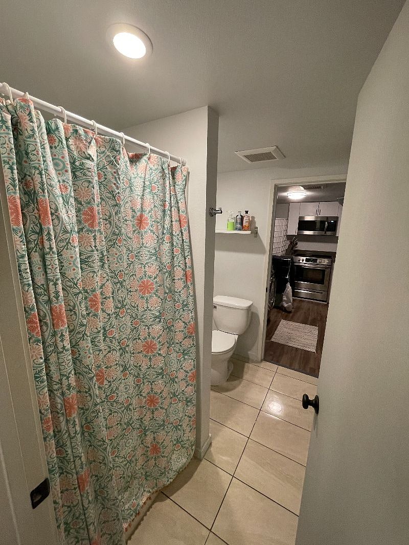 Bathroom connects to kitchen and bedroom