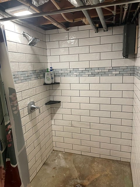 Good sized shower area with new tile in unfinished lower level area.