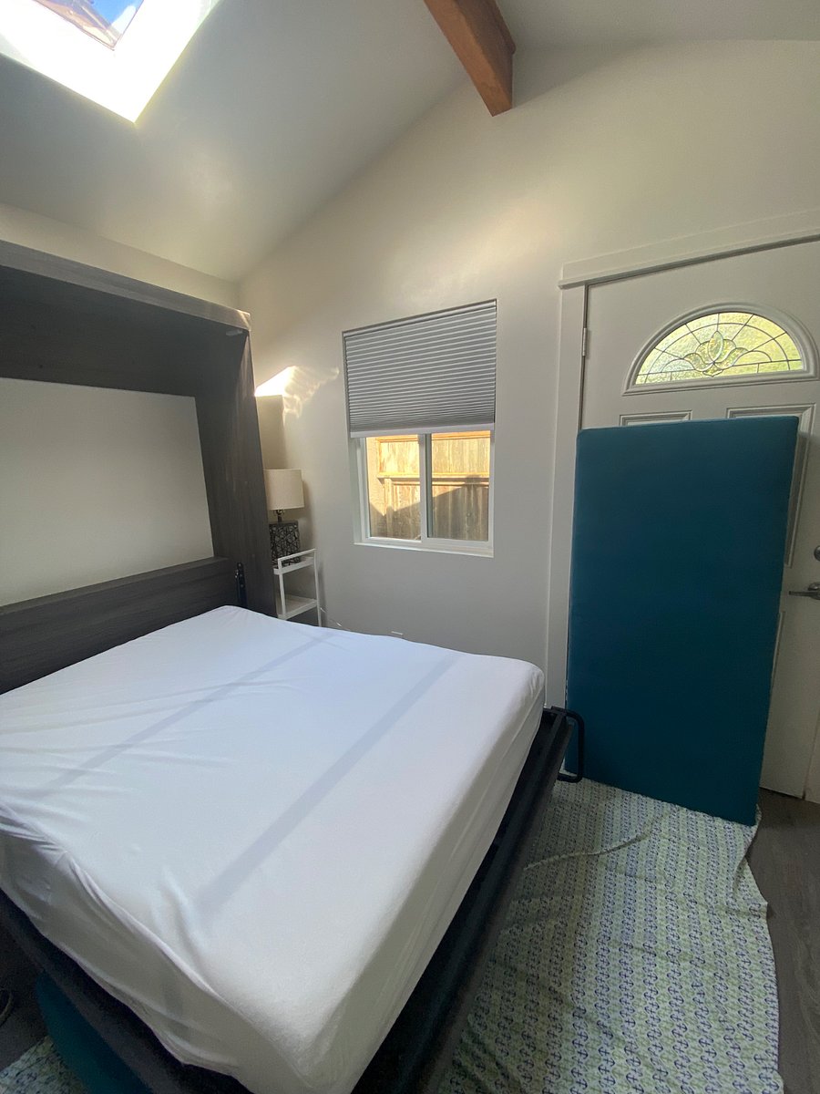 sitting couch bench and cushion stored under opened murphy bed. the sitting couch back cushion can rest against the door, or can also fit in murphy bed frame once opened like a headboard.