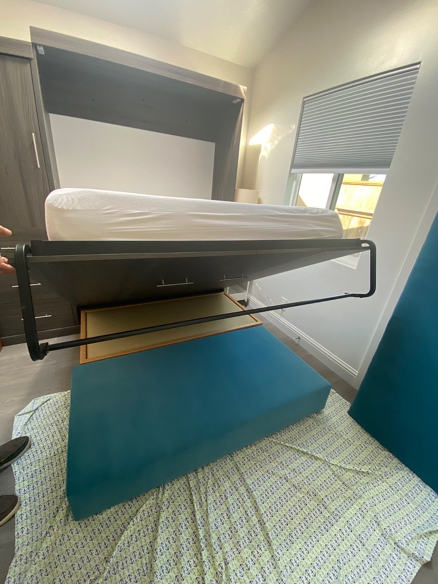 sitting couch bench and cushion broken down to store under bed when it is opened for sleeping.
