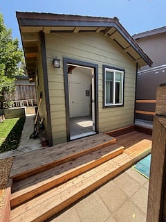 photo of backyard patio and rear door. to the left is grass area.