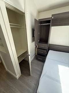 closet with door and mirror, bed opened up from murphy bed wall, 3 drawers and murphy bed closet door.