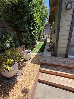 rear private fenced in patio with grass area.