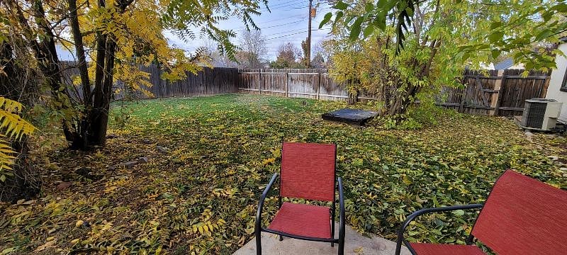 Large fenced back yard with a propane bbq grill.