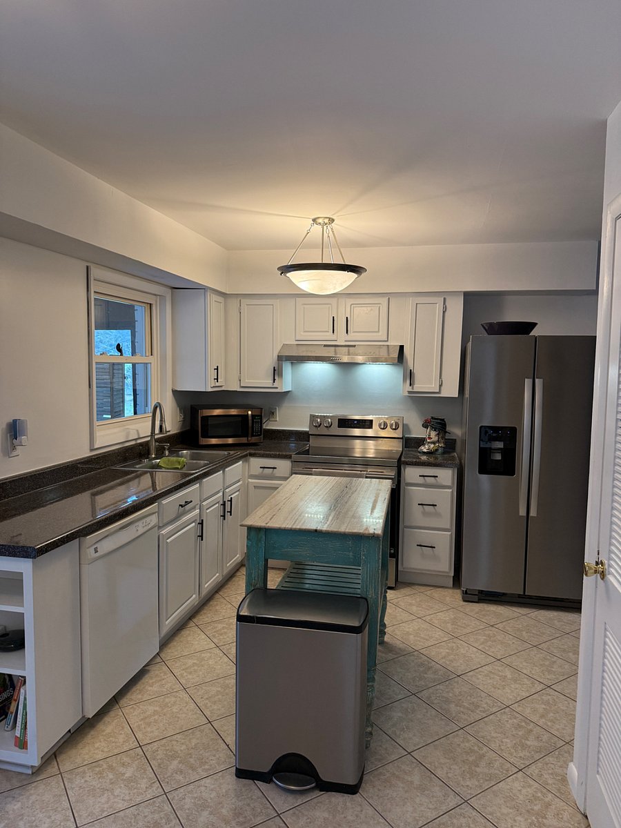 Kitchen area with all new cabinets, stove and fridge. Island and small kitchen table 