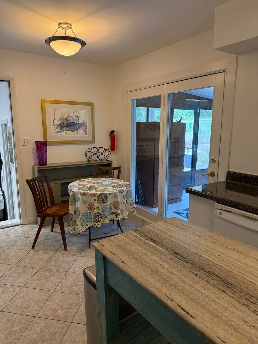 Kitchen area with all new cabinets, stove and fridge. Island and small kitchen table 