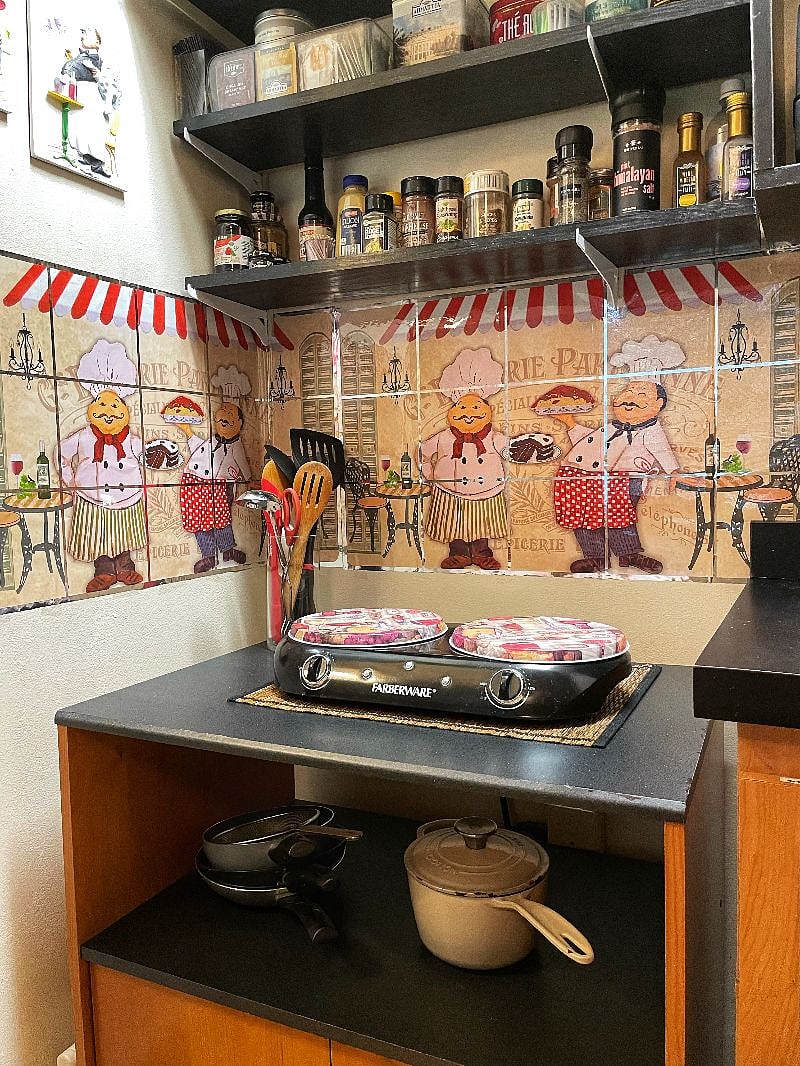 Cooking area features two electric burners, utensils, spices and condiments.