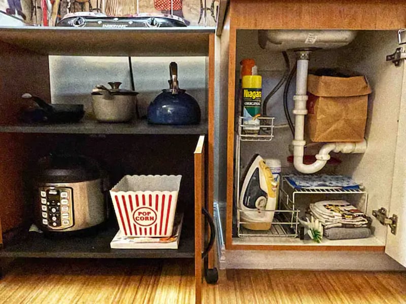 Below, an assortment of pots and pans, Instant pot, iron and cleaning products.