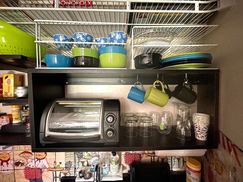 Dinnerware, toaster oven, sink and dish drainer.