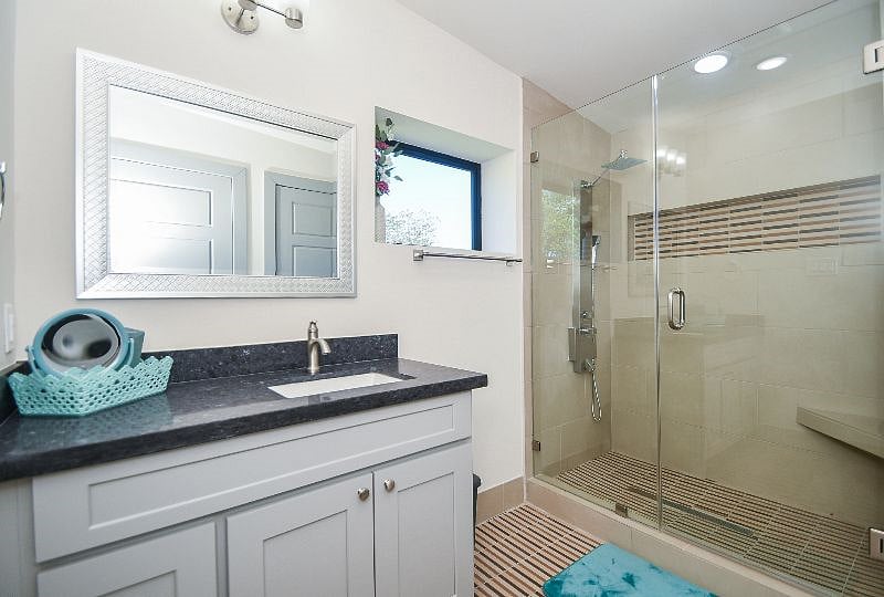 Spacious standing shower with a shower panel, seat and a huge soap niche